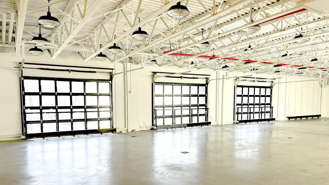 The open interior of Jóia's future Brooklyn facility, with tall garage-door windows